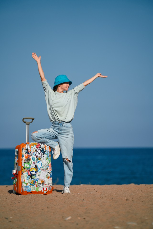 عکس یک دختر با چمدان در کنار دریا